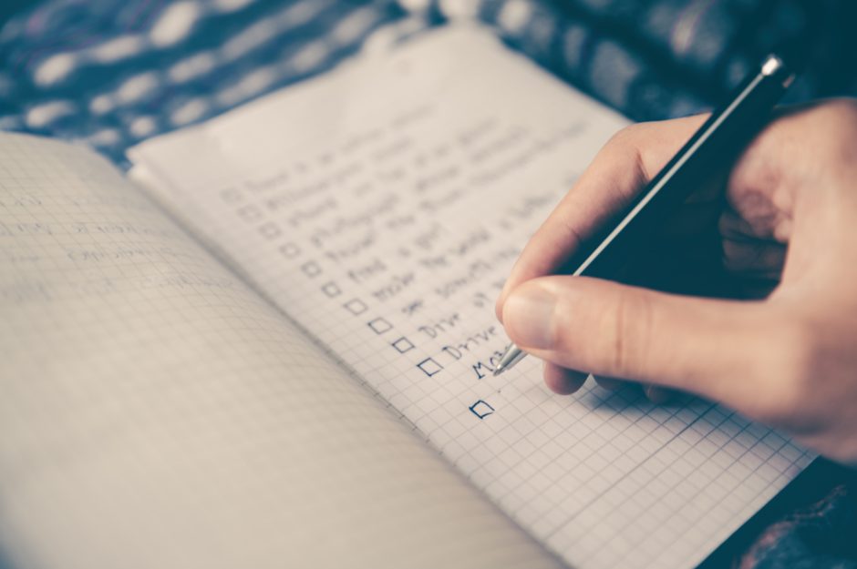 Close-up of a person's hand writing a list